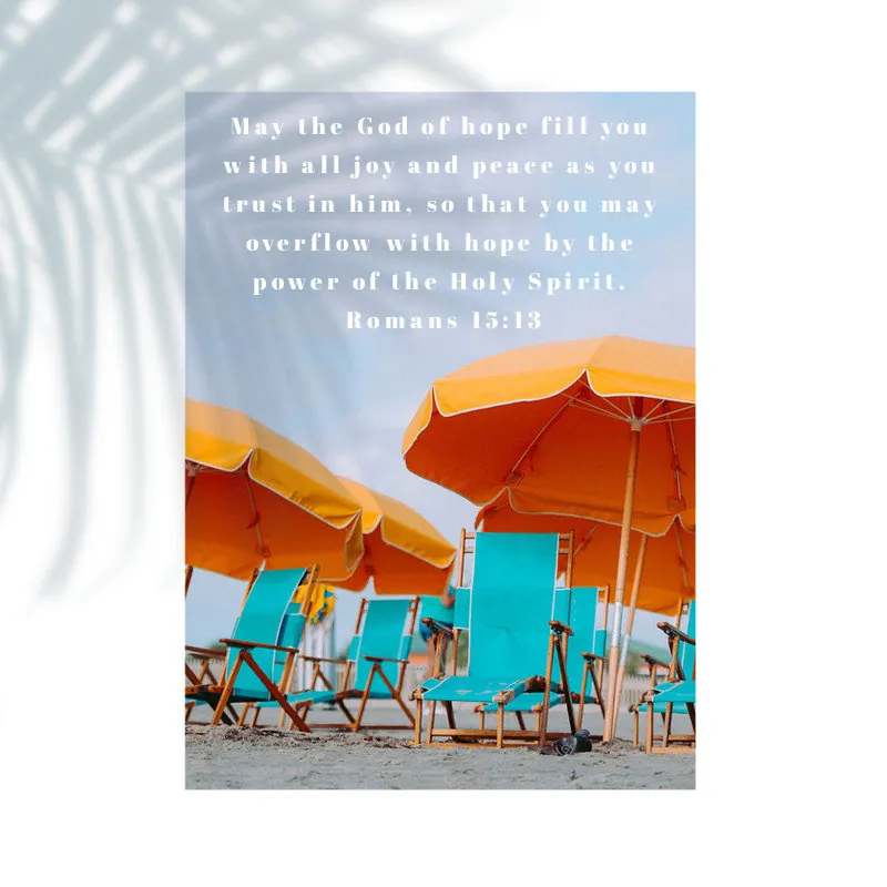 Romans 15:13 verse card above orange beach umbrellas and blue chairs